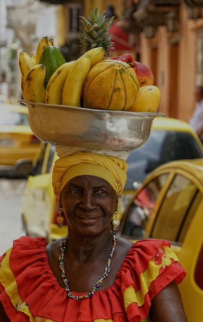 女人提着水果的碗

